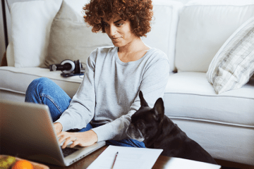 woman sitting with dog at laptop