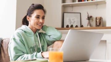 woman sitting in living room at laptop