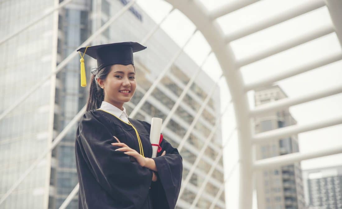 female grad student holding diploma