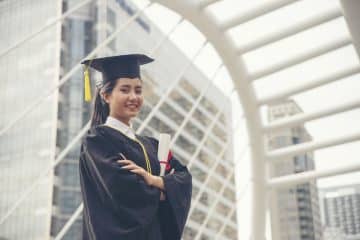 female grad student holding diploma
