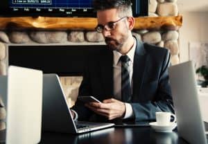 Business Man Texting on Phone at Desk