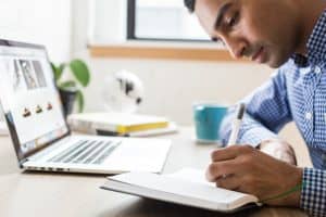 Man Writing Notes at Desk